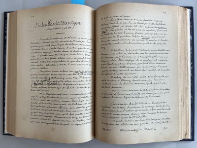 un livre ouvert avec une écriture dessus, posé sur une table
