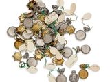 un tas de breloques en argent et en or posées sur une surface blanche