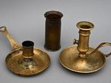 two antique brass candlesticks and a candelab on a table