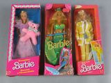 three barbie dolls are in a pink box on a table
