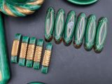 a lot of green and gold hair accessories on the table