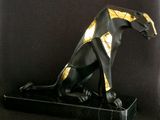 statue of a black and gold cat sitting on a marble base