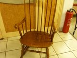 a wooden chair that is sitting on a tile floor
