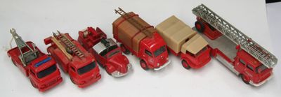 de nombreux camions de pompiers rouges miniatures alignés sur une surface blanche