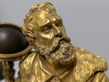 a statue of a man holding a globe on a table