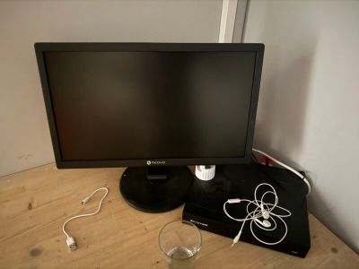 un écran d'ordinateur posé sur un bureau en bois