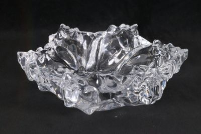 un saladier en verre transparent posé sur une surface noire, avec un fond noir