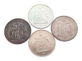a group of five coins sitting next to each other on top of a white surface