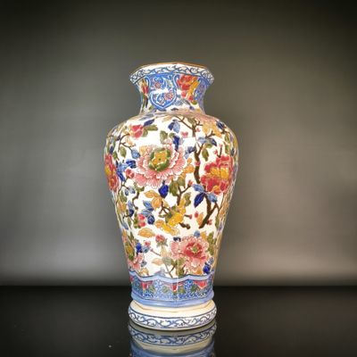 a vase that is sitting on a table with a black background