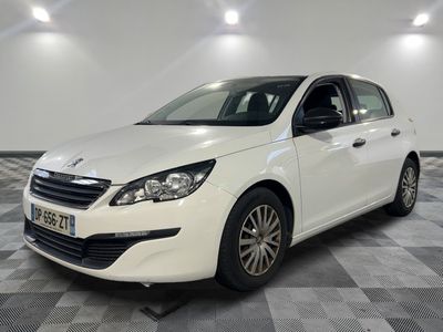 une voiture blanche est garée dans une pièce au sol en damier