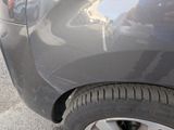 a close up of a car ' s tire with a reflection of a person in the background