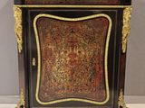 une commode peinte en noir et or, avec un plateau en marbre
