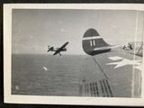 an old photo of a plane flying over the ocean