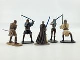 star wars action figures sit on a white surface