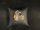 an image of a gold and pink stone ring on a black pillow