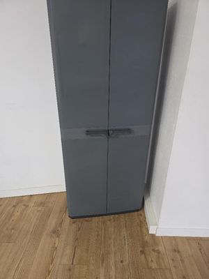un grand réfrigérateur gris dans un coin de la pièce