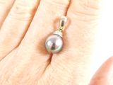 a person holding a ring with a pearl on it