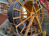 un gros tuyau jaune posé sur un chariot à l'intérieur d'un bâtiment