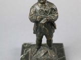 bronze figurine of a man in a pirate hat holding a gun