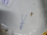 a close up of a white and gold vase with a tag on it