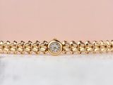 un bracelet en or orné d'un diamant serti au centre