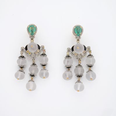 une photo d'une paire de boucles d'oreilles ornées de pierres vertes et blanches