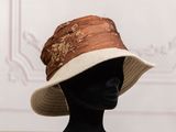 brown and white hat on a mannequin head on display