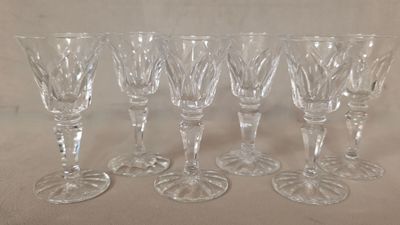 six verres à vin sont alignés sur une table