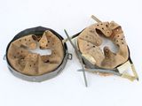 two metal pans with holes in them on a white surface