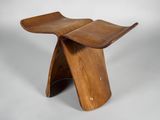 un gros plan d'un tabouret en bois avec une assise incurvée