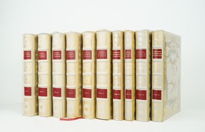 six livres alignés sur une surface blanche, avec un ruban rouge