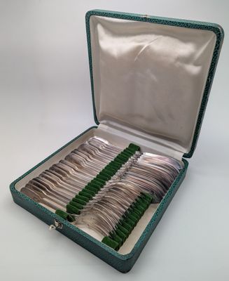 des couverts dans un étui vert sur fond blanc