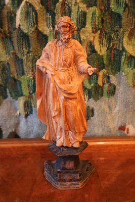 une statue représentant un homme tenant un livre posé sur une table