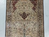 a beige and red rug with a medallion design on it