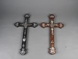 two wooden crosses with white and brown designs on them