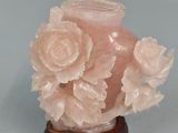 a pink vase with flowers in it on a table