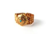 une image représentant une bague en or ornée d'une pierre turquoise au centre