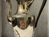 a silver tea pot sitting on a white table