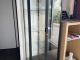 une vitrine en verre dans le coin d'une pièce
