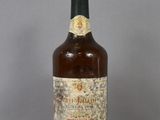 an old bottle of wine sitting on top of a glass table