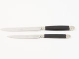 two black and white knives on a white surface