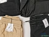 three pairs of men ' s pants with tags on them sitting on a table