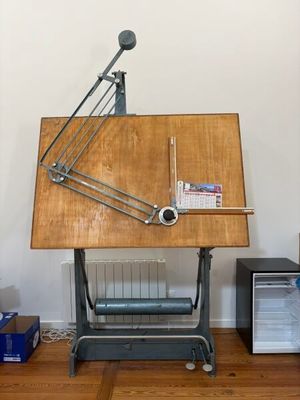 a wooden table with a drawing board on top of it