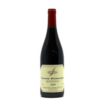 the bottle of wine is sitting on a white surface