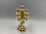 an antique brass candelabra with five candles on a stand