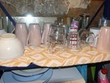 a shelf with cups and glasses on it in a kitchen