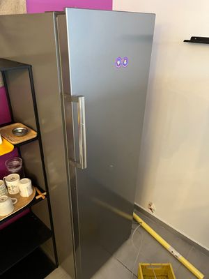 un réfrigérateur argenté dans un coin de la pièce