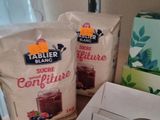 two bags of food sitting on a counter next to a box of fruit