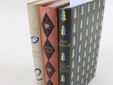 trois livres empilés sur une surface blanche