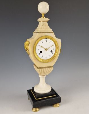 une image représentant une horloge posée sur un socle, surmontée d'une boule